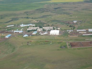 Rosebud Colony today, notice the residences and communal kitchen in the center screened by trees, and the barns and feedlots surrounding. The Rosebud River is in the background. (Photo by Simon M. Evans)
